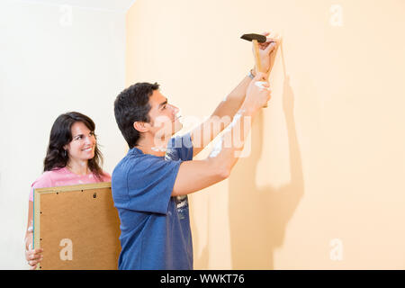 Junge Hispanic Paar hängende Bild an der Wand Stockfoto