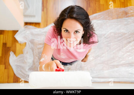 Junge Hispanic Frau Malerei Wand von neue Heimat, hohe Betrachtungswinkel Stockfoto