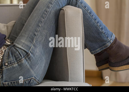 Frau in Hosen Lounges in Sessel Stockfoto