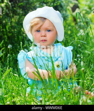 Clouse-up Portrait hübsches kleines Mädchen im Gras sitzen im Park Stockfoto