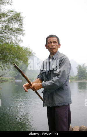 CHINA - 16. Mai, ein Fischer ist Paddeln der Bambus Boot entlang der Yulong River in Guilin, China am 15. Mai 2010. Stockfoto