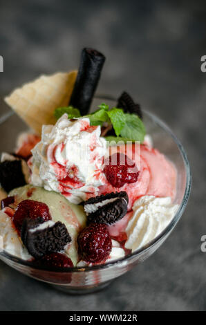 Himbeere und Pistazie Eisbecher Dessert im Glas Schale mit Schokolade Kekse und Beeren Stockfoto