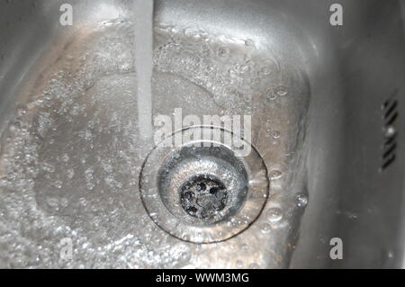 Wasserdurchfluss in den Abfluss in der Küche Stockfoto