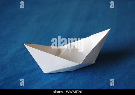 Origami Papier Boot auf blaues Wasser isoliert Stockfoto