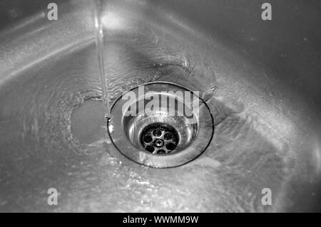 Wasserdurchfluss in den Abfluss in der Küche Stockfoto