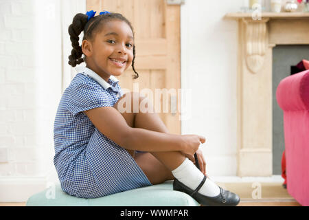 Junges Mädchen im vorderen Flur Befestigung Schuh und lächelnd Stockfoto