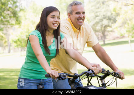 Mann und Mädchen auf dem Fahrrad im freien Lächeln Stockfoto