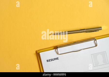 Überprüfung Fortsetzen der Bewerber auf die Zwischenablage mit einem Stift. Ansicht von oben Büro Schreibtisch. Stockfoto