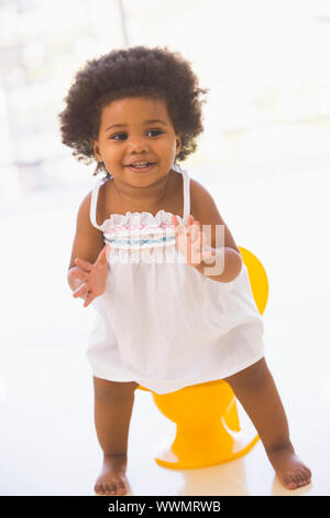 Baby Töpfchen lächelnd drinnen Los Stockfoto