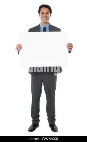 Junger Geschäftsmann hält die leeren Plakatwand, in voller Länge anzeigen Stockfoto