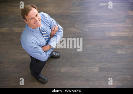 Geschäftsmann, stehen im Innenbereich lächelnd Stockfoto