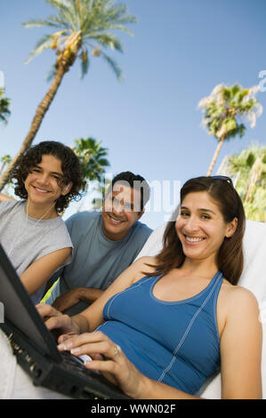 Familie mit Laptop außerhalb Stockfoto