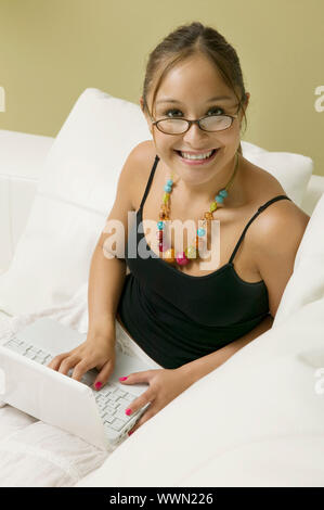 Frau mit Laptop auf Sofa Stockfoto