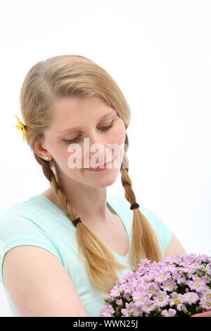 Portrait der blonden Frau, die an Blüten Rosa auf weißem Hintergrund ist auf der Suche Stockfoto