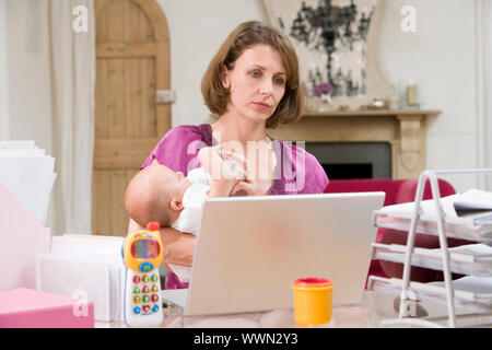 Mutter und Baby im home-Office mit laptop Stockfoto