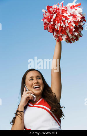 Cheerleader mit Handy Stockfoto