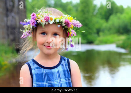 Mädchen in der Kranz mit einem Bouquet von Gänseblümchen. Stockfoto