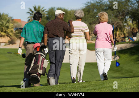 Freunde gehen auf Golfplatz Stockfoto