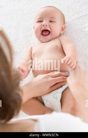 Mutter von wechselnden Babywindel drinnen Stockfoto