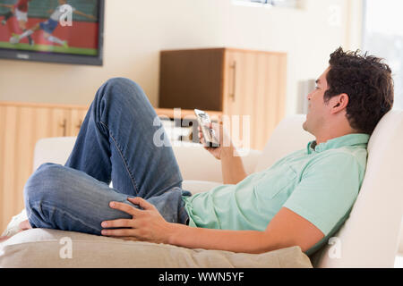 Mann im Wohnzimmer vor dem Fernseher Stockfoto