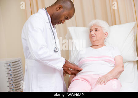 Doctor giving Checkup zur Frau im Prüfungsraum Stockfoto