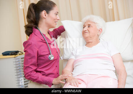 Doctor giving Checkup zur Frau im Prüfungsraum Stockfoto
