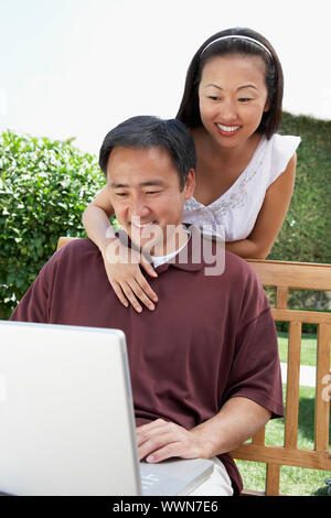 Paar mit Laptop im Garten Stockfoto