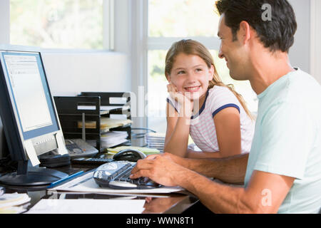 Mann und junge Mädchen im home-Office mit Computer lächelnd Stockfoto