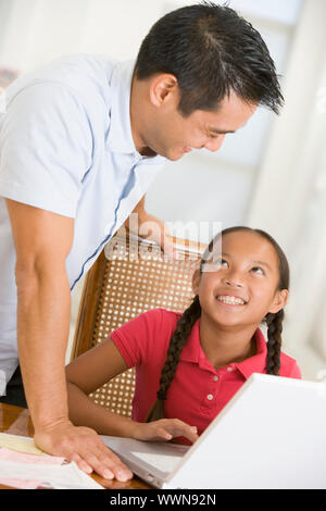 Mann und junge Mädchen mit Laptop im Speisesaal Lächeln Stockfoto