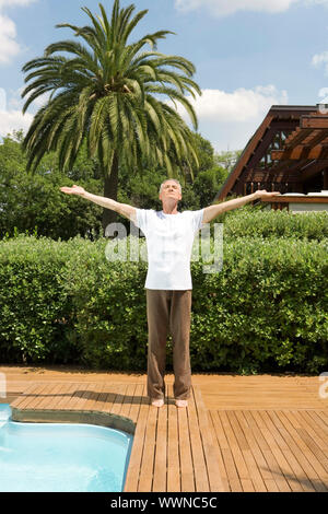 Ältere Mann tut Yoga Pool Stockfoto