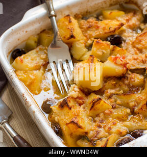 Fisch mit Kartoffeln und Oliven in Ofen in kleine Kasserolle gekocht Stockfoto