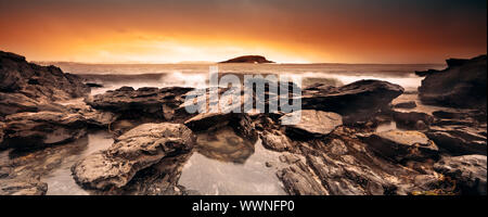 Surfen Sie über Felsen Rollen Stockfoto