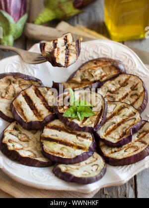 Gegrillte Auberginen gewürzt mit Olivenöl auf Serviette auf einem Holztisch Stockfoto