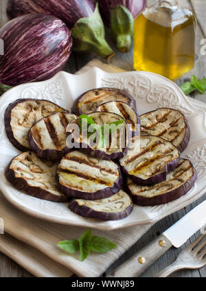 Gegrillte Auberginen gewürzt mit Olivenöl auf Serviette auf einem Holztisch Stockfoto