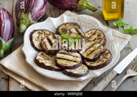 Gegrillte Auberginen gewürzt mit Olivenöl auf Serviette auf einem Holztisch Stockfoto