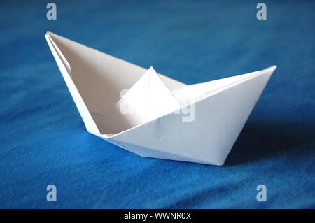 Origami Papier Boot auf blaues Wasser isoliert Stockfoto