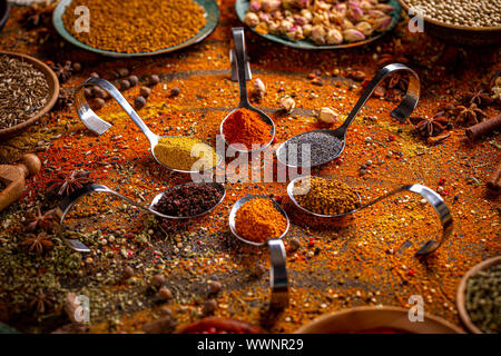 Gewürze und Kräuter in Metall Löffel. Bunte natürliche Zusatzstoffe. Stockfoto