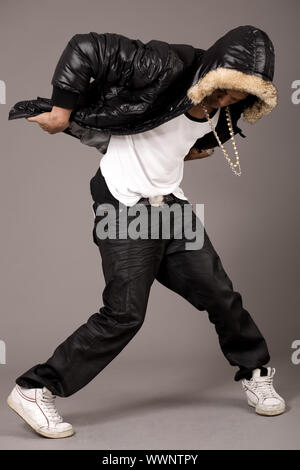 Man führt hip Pop-Schritte auf grauem Hintergrund Stockfoto