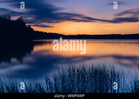 Einer langen Belichtungszeit Bild von einem Sonnenuntergang und Nachleuchten auf See angenehm in den Adirondack Mountains, NY, USA Stockfoto