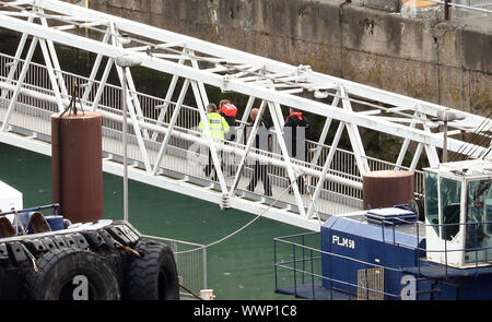 Eine Gruppe von Menschen gedacht, um Migranten werden zu Ufer durch Grenze Offiziere im Hafen von Dover, Kent nach einem kleinen Boot Vorfall im Kanal. Stockfoto