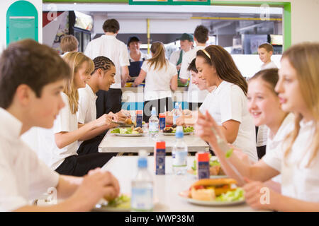 Schüler mit Mittagessen im Speisesaal Stockfoto