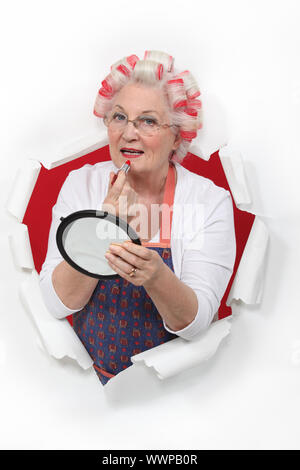 Alte Frau in Rollen Lippenstift Stockfoto
