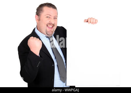Ein erfolgreicher Geschäftsmann hält ein leeren Zeichen Stockfoto
