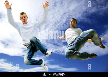 Zwei junge Männer in die Luft springen Stockfoto