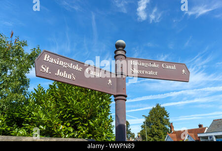 Wegweiser auf dem Leinpfad der Basingstoke Canal in Woking mit Wegbeschreibungen und nach der Nähe der Reiseziele Stockfoto