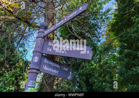 Wegweiser auf dem Weg zum Basingstoke-Kanal in Woking mit Wegbeschreibung zu nahe gelegenen Reisezielen, St John's, Sheerwater, Stadtzentrum Stockfoto