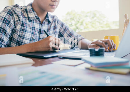 Grafiker und Fotograf arbeitet auf dem Computer und verwendet Grafiktablett. Stockfoto