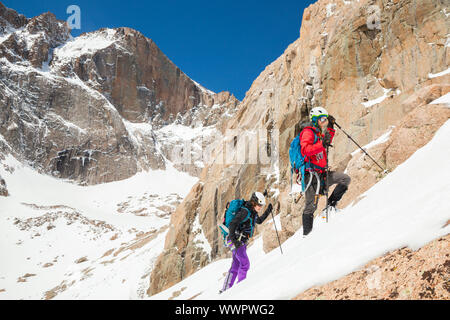 Mylène Jacquemart (links) und Jan Rouš wanderung Martha Couloir auf dem Berg Lady Washington, Rocky Mountain National Park, Colorado. Longs Peak ist in der Ba Stockfoto