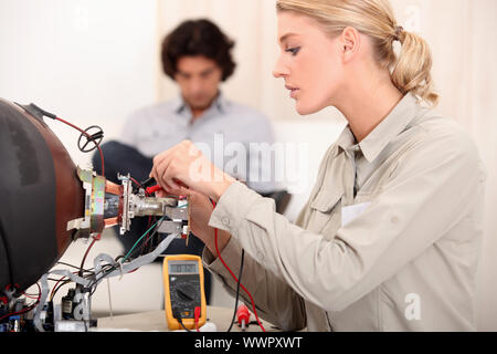 Frau, die einen Fernseher reparieren Stockfoto