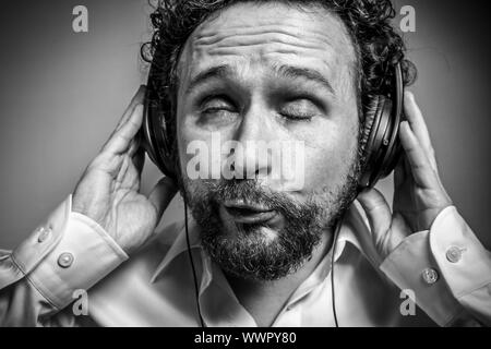 Genießen Sie die Musik, Mann mit intensiven Ausdruck, weißes Hemd Stockfoto